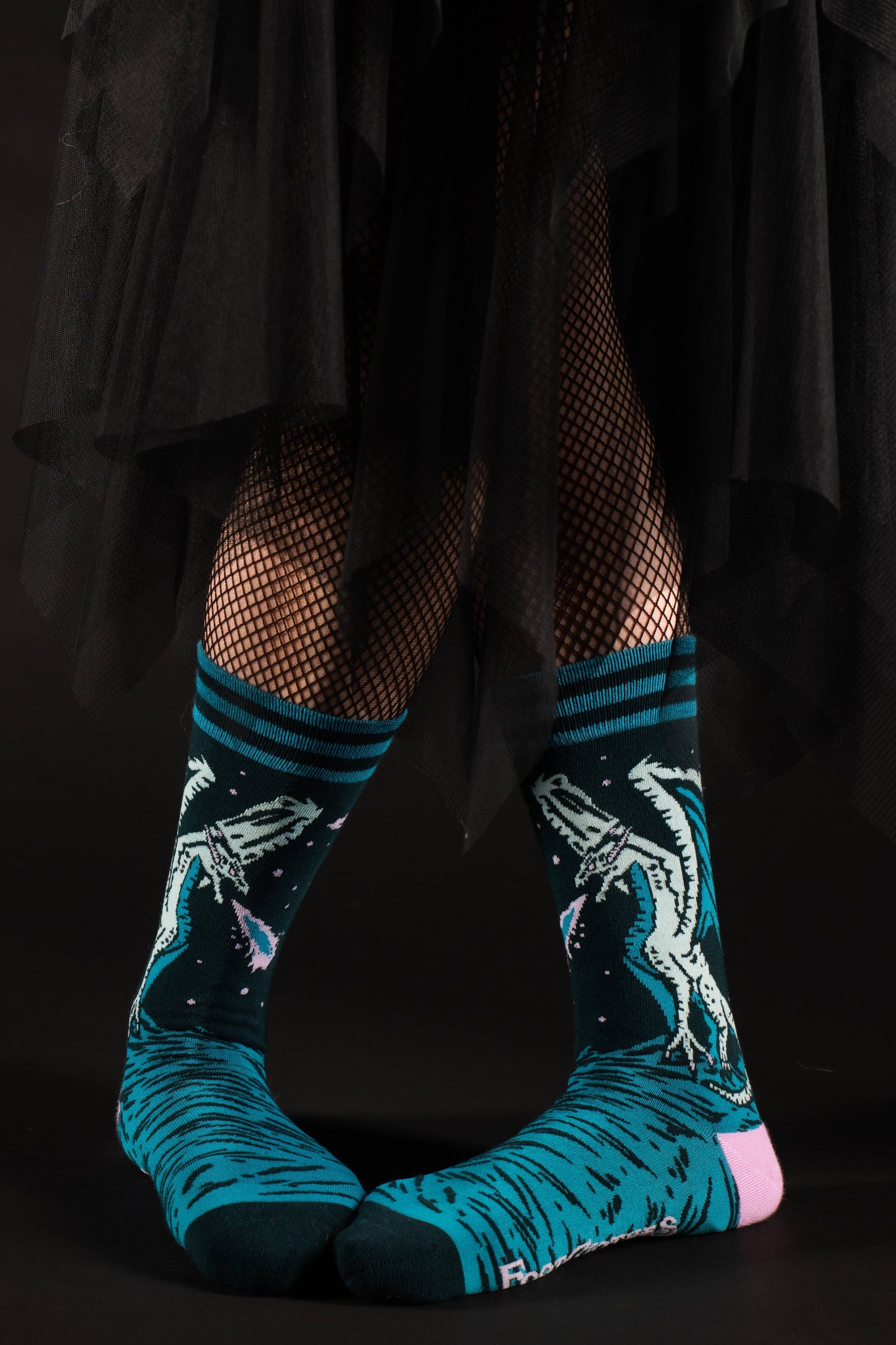 Model wearing a of socks featuring an evil dragon. Blue legs, green heel, toe and cuff.