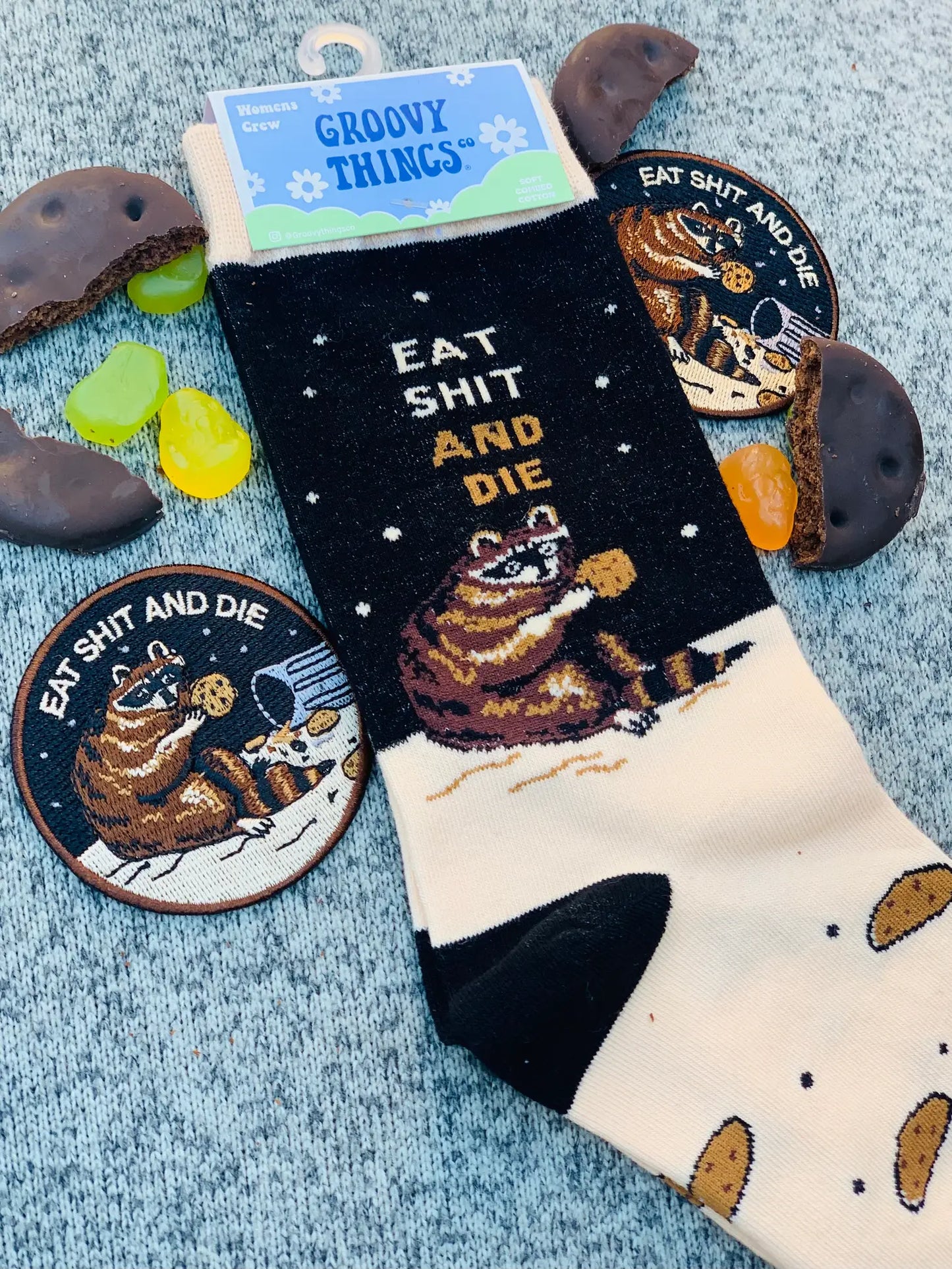 Eat S**t and Die Socks. A pair of socks with a bold slogan and racoon eating out of the bin detail. Black toe, cuff and heel.
