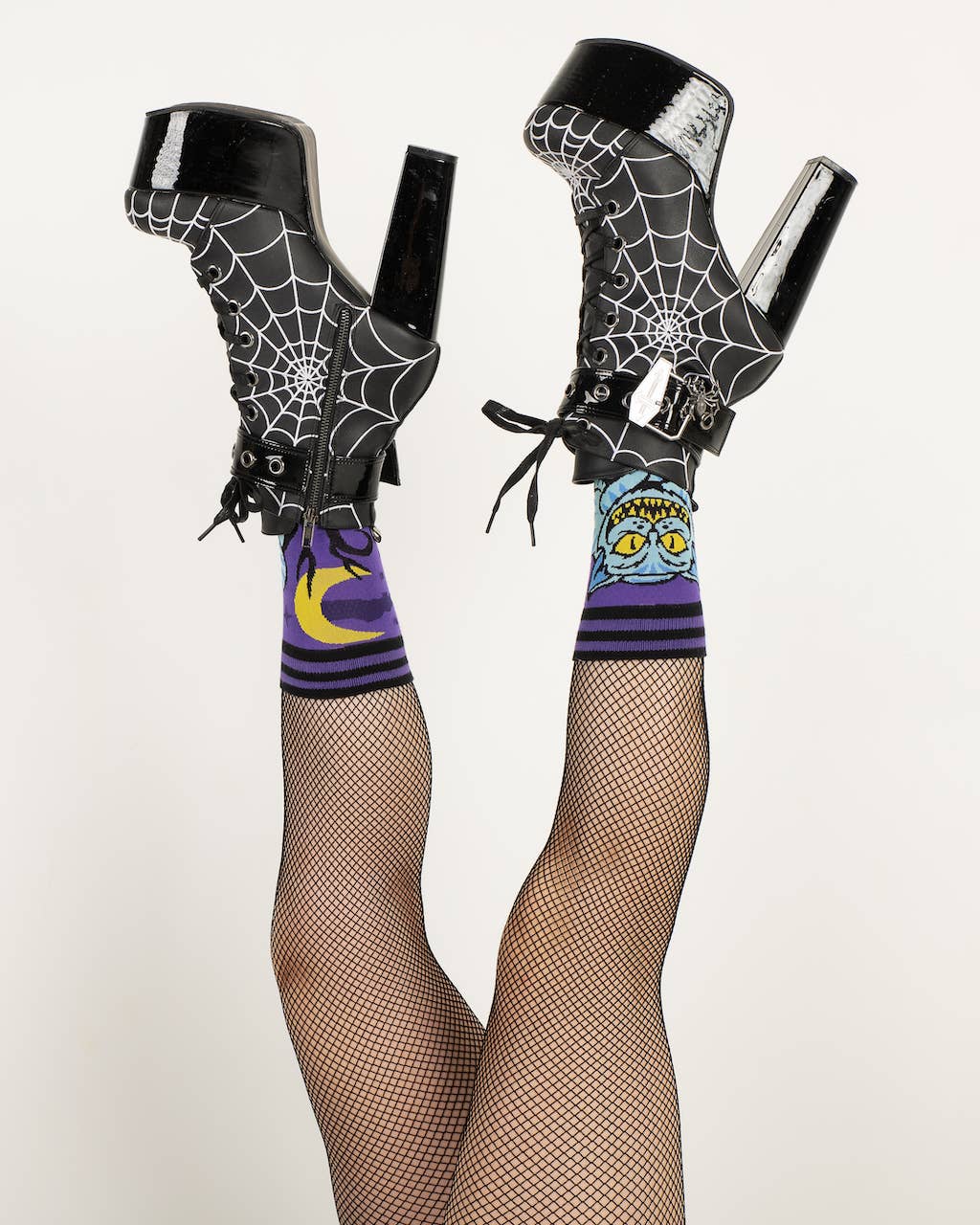 A model wearing a pair of socks featuring the cheshire cat. Purple legs, black heel, cuff and toe.