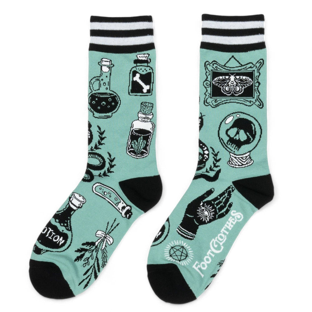
                      
                        A model wearing a pair of socks featuring occult and magic symbols. Green legs, black, heel and toe. 
                      
                    