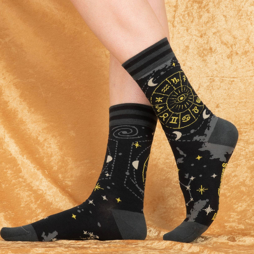 
                      
                        A model wearing a pair of socks featuring astrology symbols. Black legs, grey heel, toe and cuff. 
                      
                    