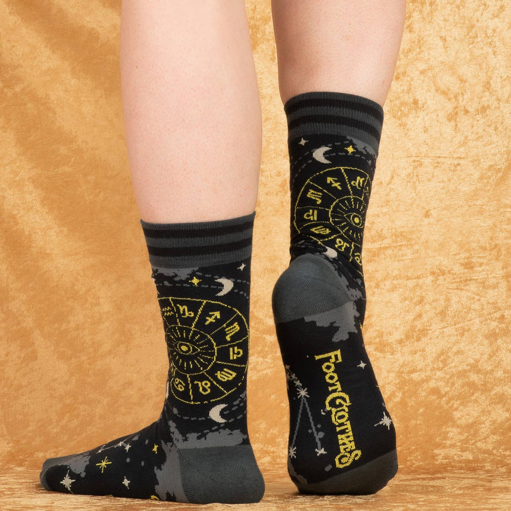 
                      
                        A model wearing a pair of socks featuring astrology symbols. Black legs, grey heel, toe and cuff. 
                      
                    