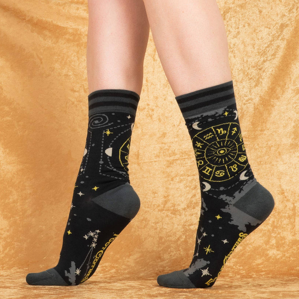 
                      
                        A model wearing a pair of socks featuring astrology symbols. Black legs, grey heel, toe and cuff. 
                      
                    