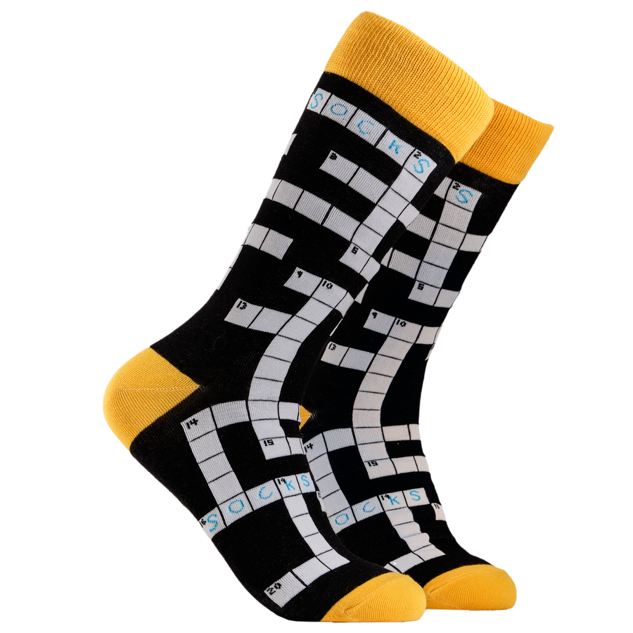 Crossword Socks. A pair of socks depicting Crosswords. Black legs, yellow cuff, heel and toe.