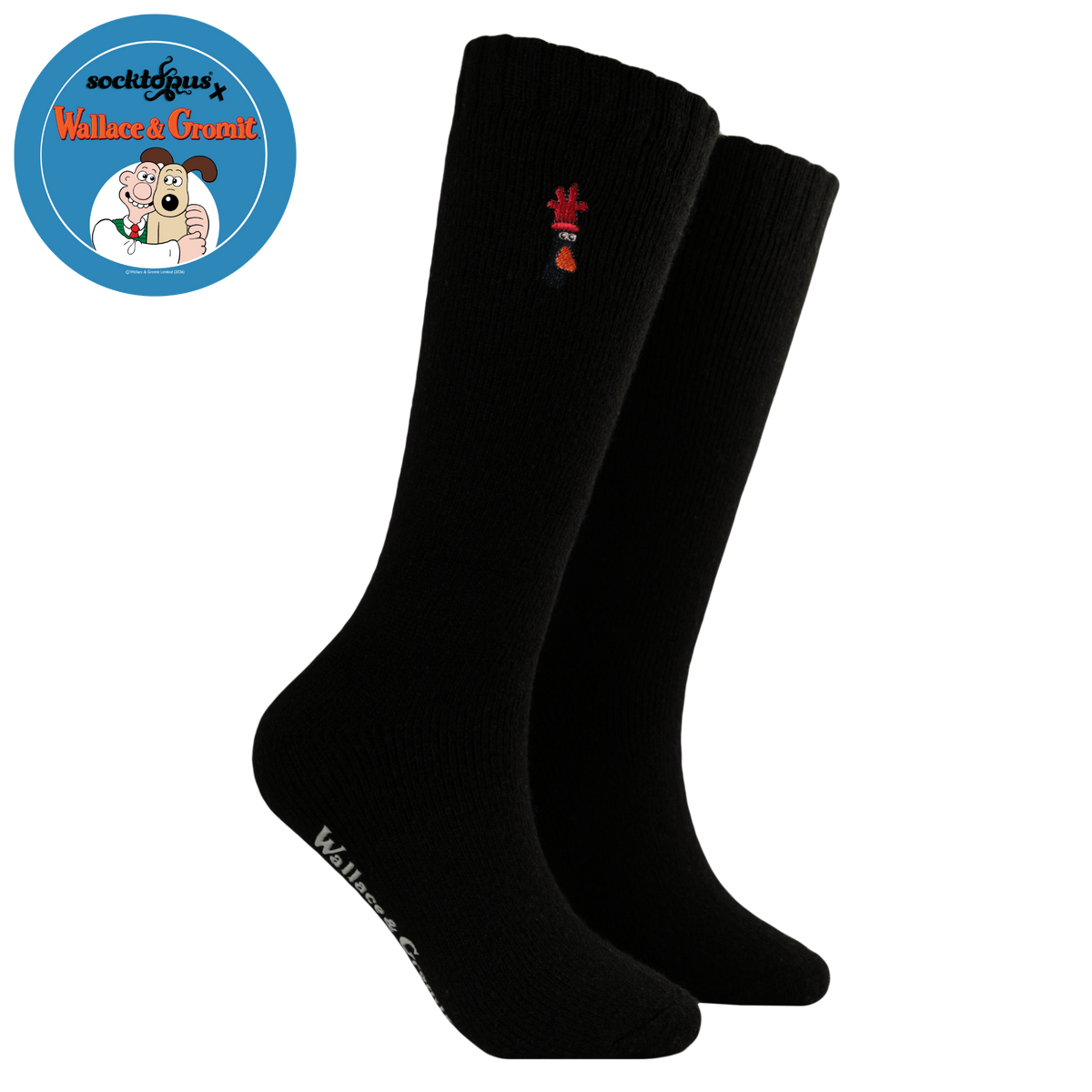 A pair of black crew socks with a small red and orange embroidered Feathers McGraw head near the top cuff and white text branding on the sole, shown against a plain white background.

