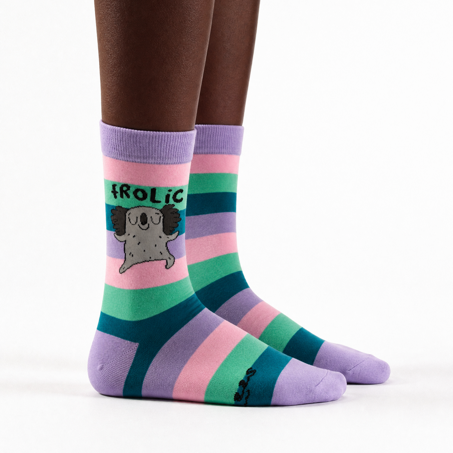A pair of crew socks with horizontal stripes in purple, teal, pink, and mint green, featuring a cartoon pug graphic and the word 'FROLIC' on the side, shown on a model's feet against a white background.