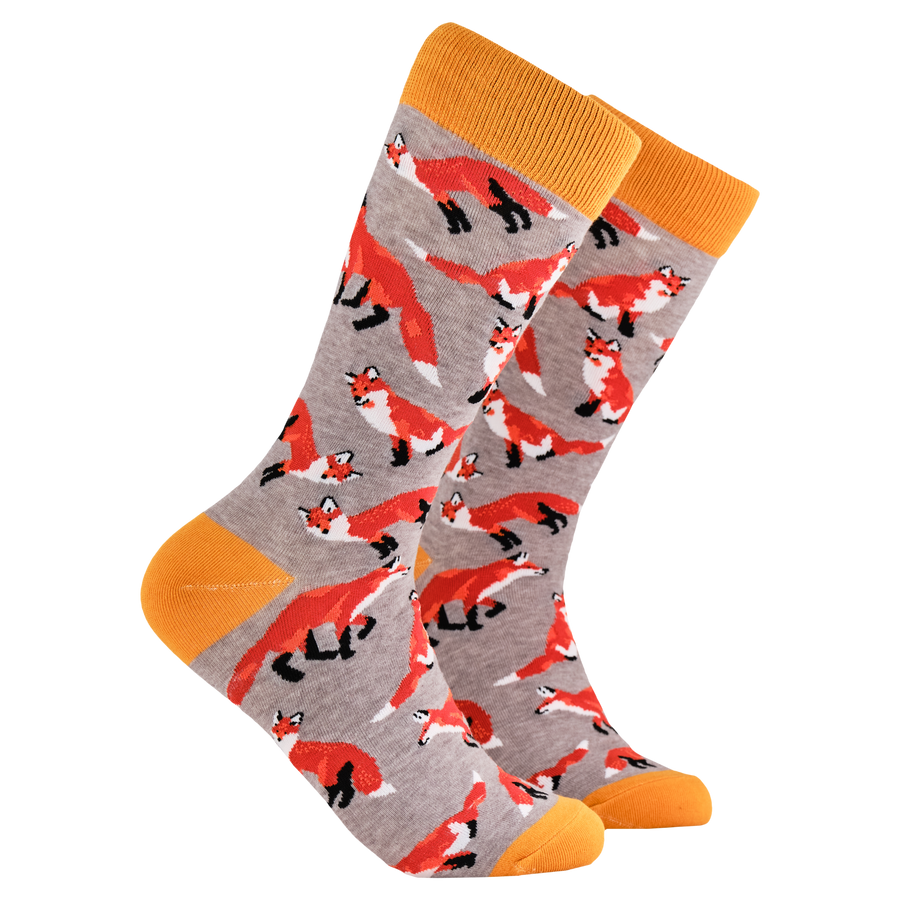 Foxes Socks. A pair of socks depicting playful foxes. Grey legs, orange cuff, heel and toe.