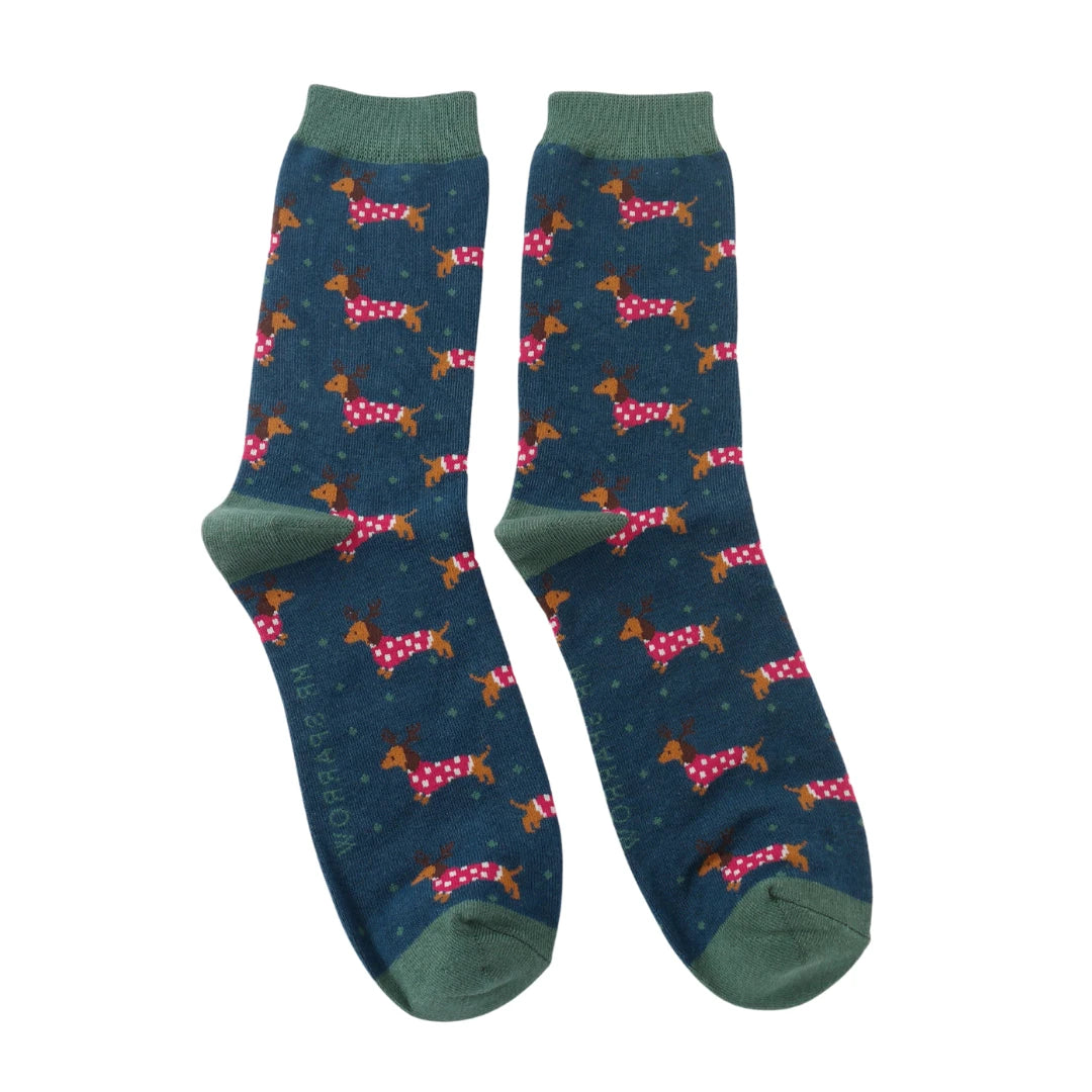 A pair of socks with a festive sausage dog pattern. Dark blue legs, dark green heel, toe and cuff. 