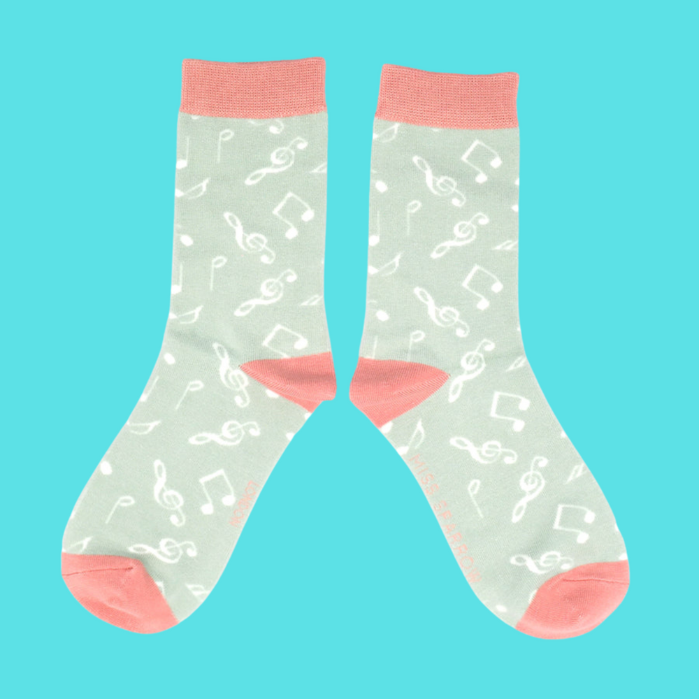 
                      
                        A pair of socks with a music note motif. Light green legs, pink heel toe and cuff. 
                      
                    
