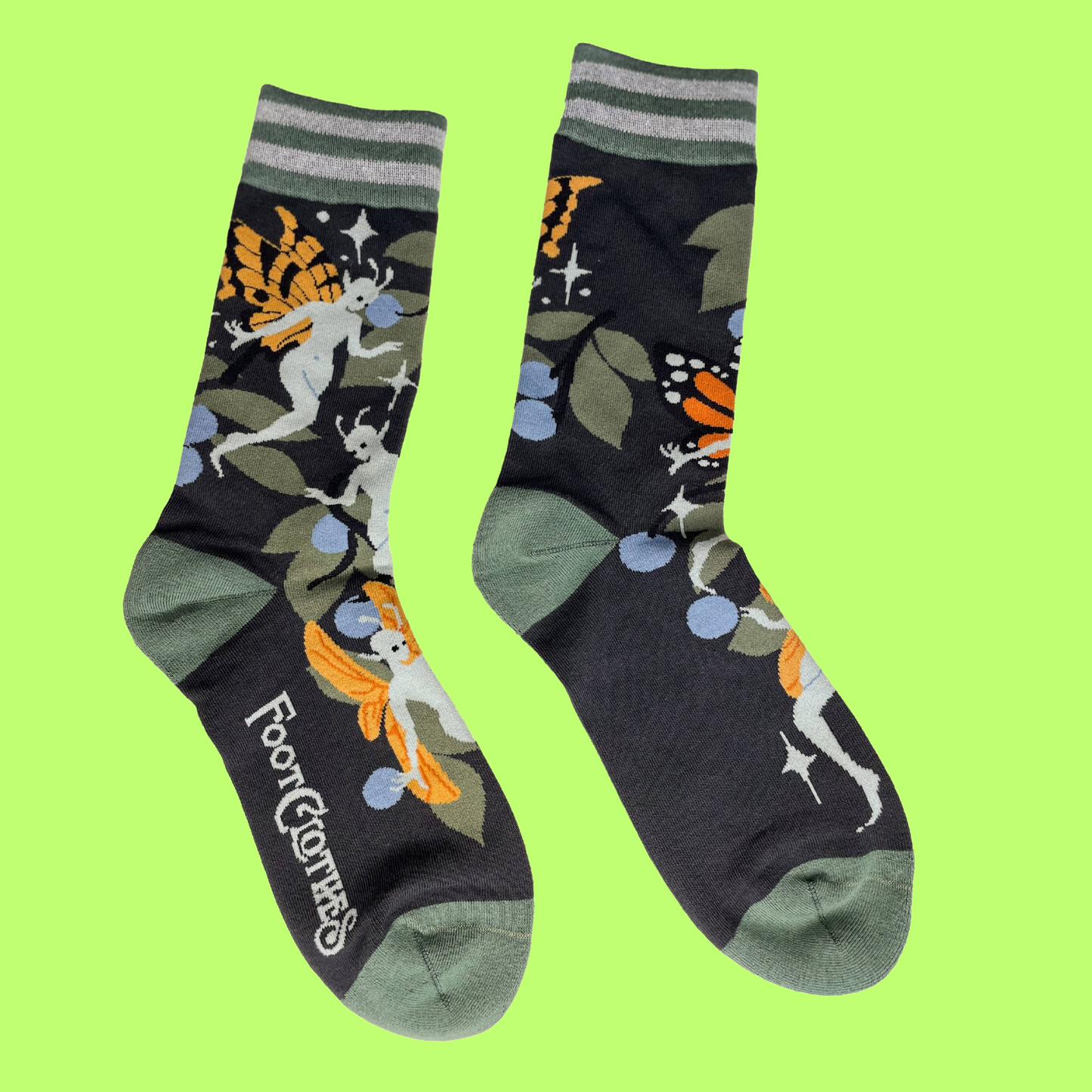 A pair of socks featuring fairies. Black legs, green heel, toe and cuff. 
