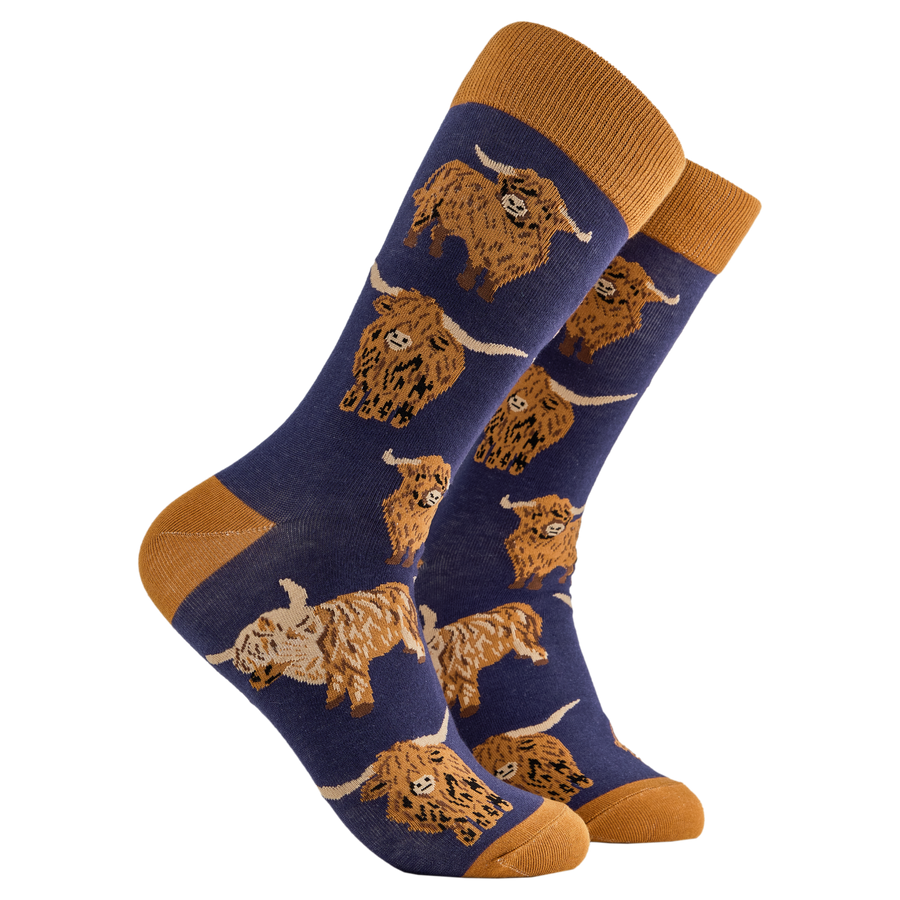 Highland Cow Socks - Och Aye the Moo! A pair of socks depicting highland cows. Blue legs, brown cuff, heel and toe.