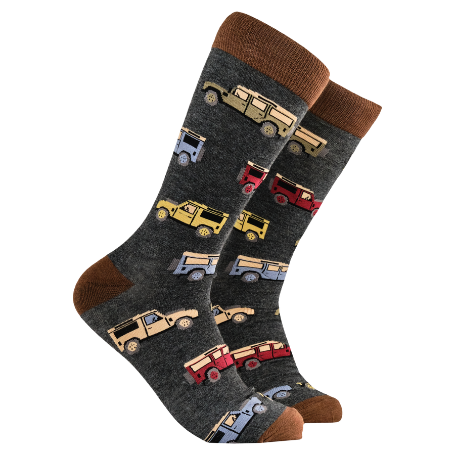 A pair of socks with various off-road vehicles printed on them, predominantly in a grey color with brown at the cuffs.