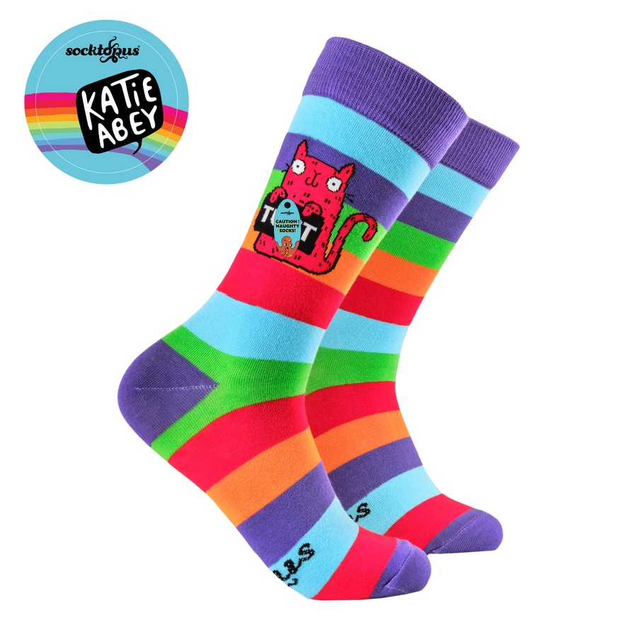Colorful striped socks with a cat design on a white background, featuring the brand 'Katie Abbey'.