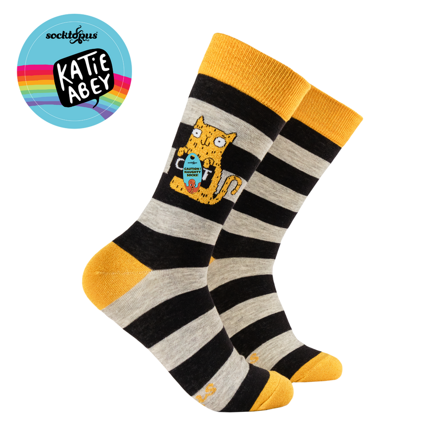 Striped socks with a cat design and yellow accents, featuring the brand 'Katie Abbey'.