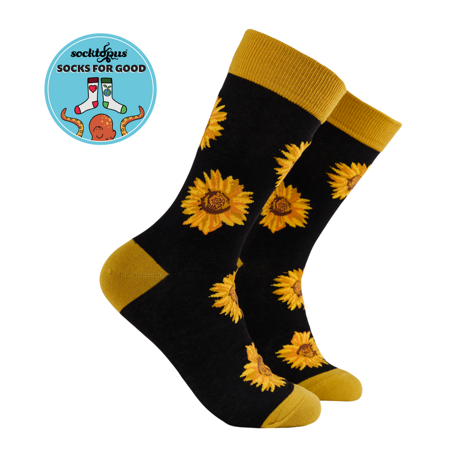 A pair of black bamboo socks with a pattern of yellow sunflower heads and green leaves.