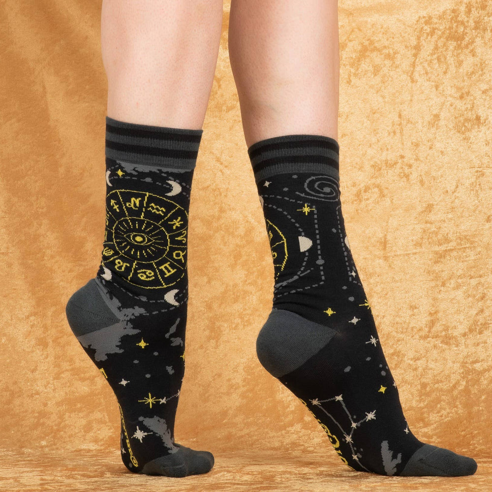 
                      
                        A model wearing a pair of socks featuring astrology symbols. Black legs, grey heel, toe and cuff. 
                      
                    