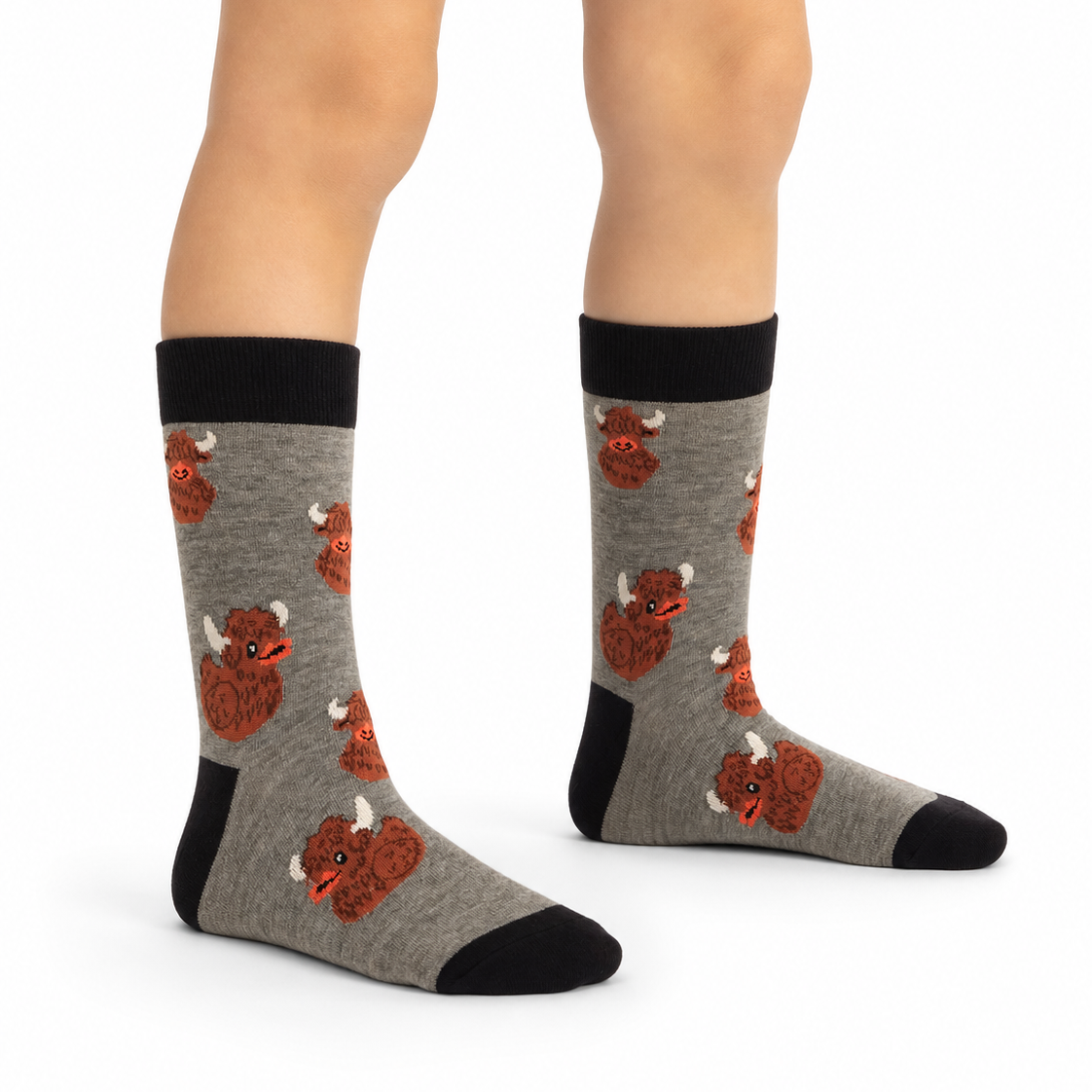 Gray crew socks with a black cuff, heel, and toe, featuring a repeating pattern of red and orange cartoon buffalo, shown on a model's feet against a white background.