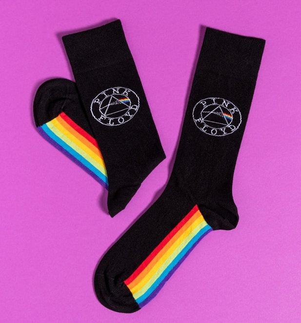 A pair of black socks with the pink floyd logo and the spectrum on the sole. 
